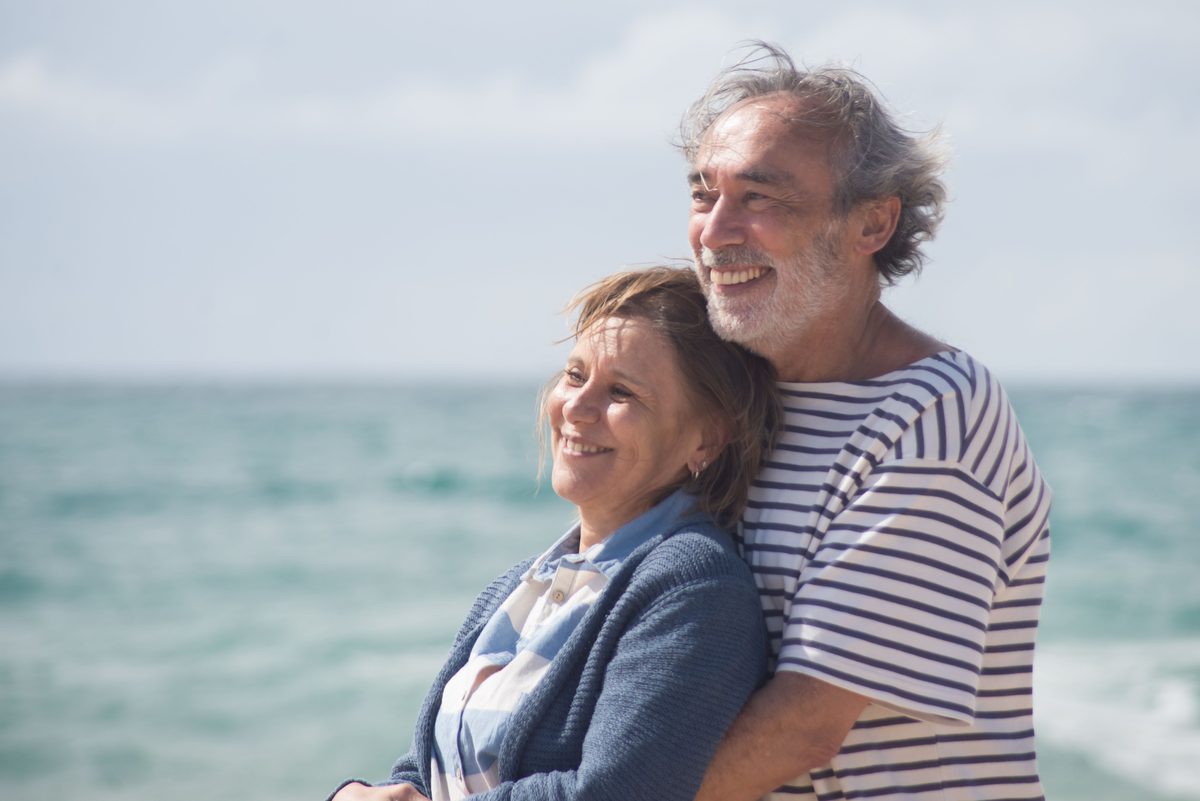 Mature couple smiling together near the coast