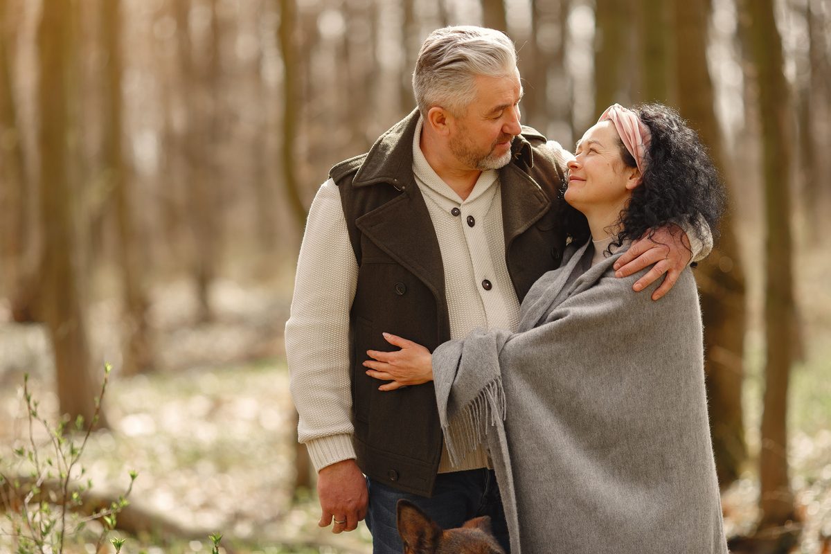 Mature couple embracing on a woodland path